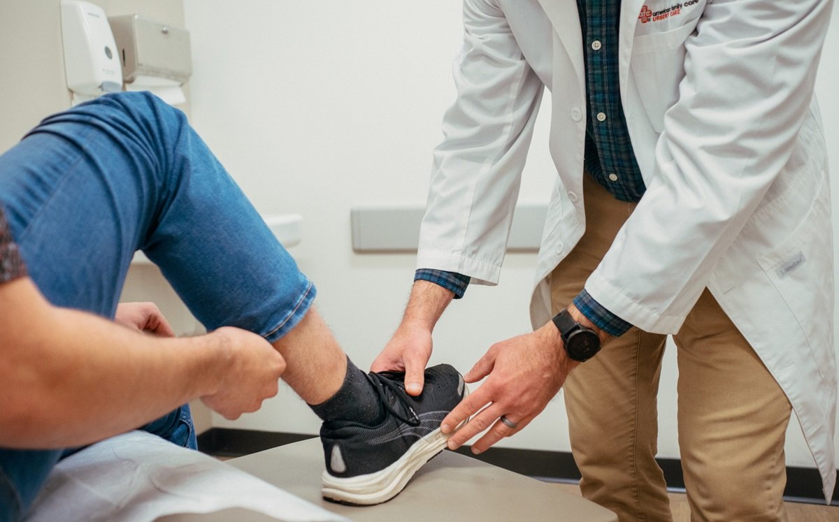 Medical provider examining patient's ankle injury Medical provider examining patient's ankle injury