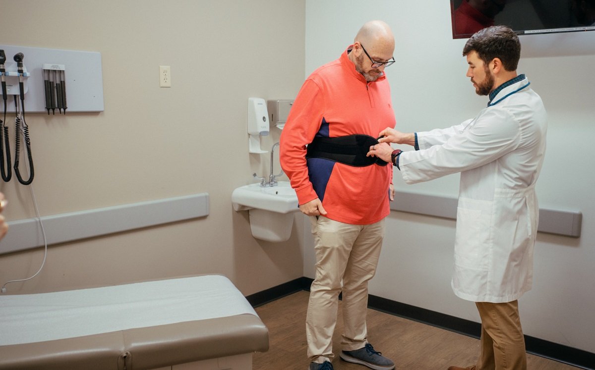 medical provider fitting patient for a back brace medical provider fitting patient for a back brace