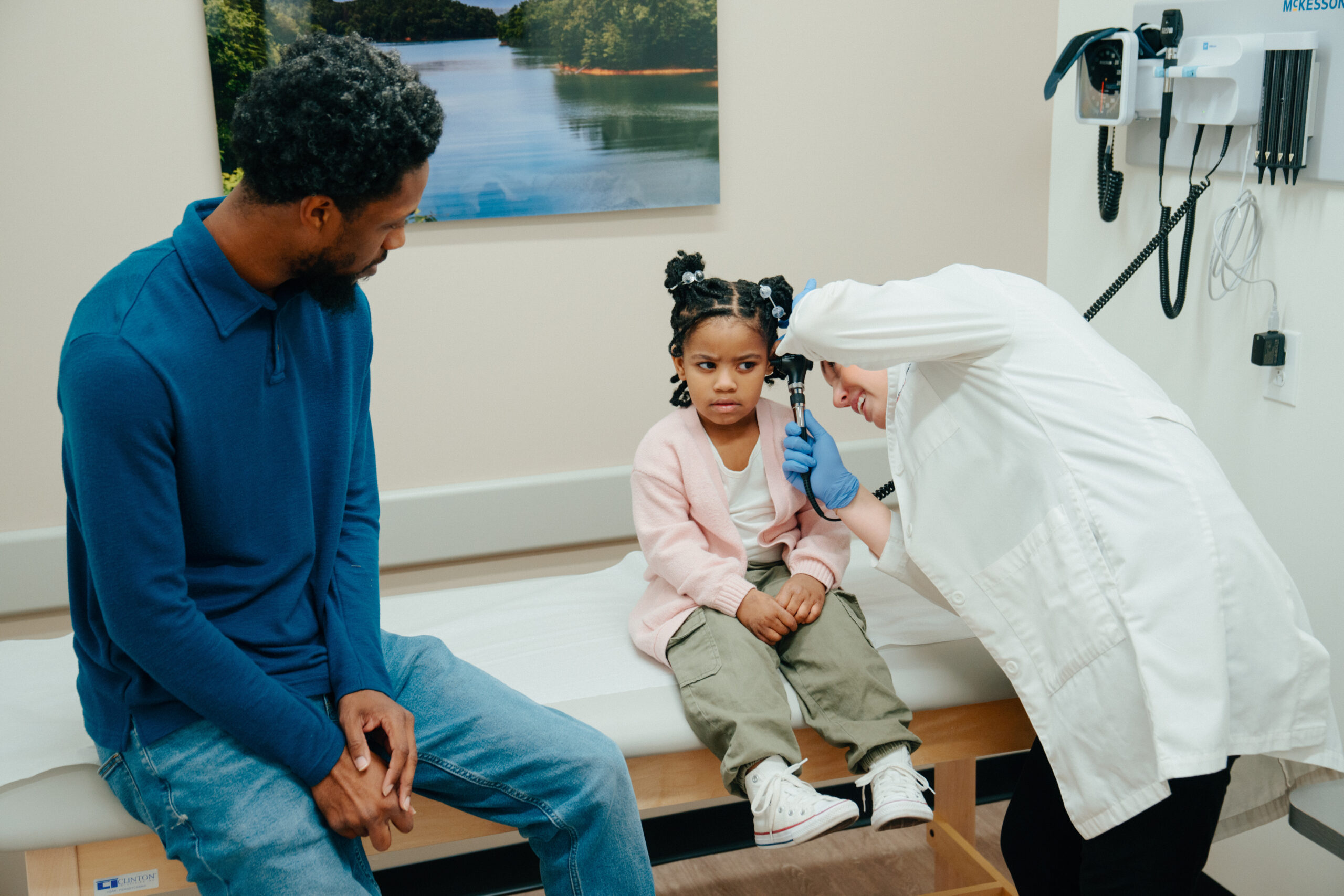 Child being examined for an ear infection at a pediatric urgent care
